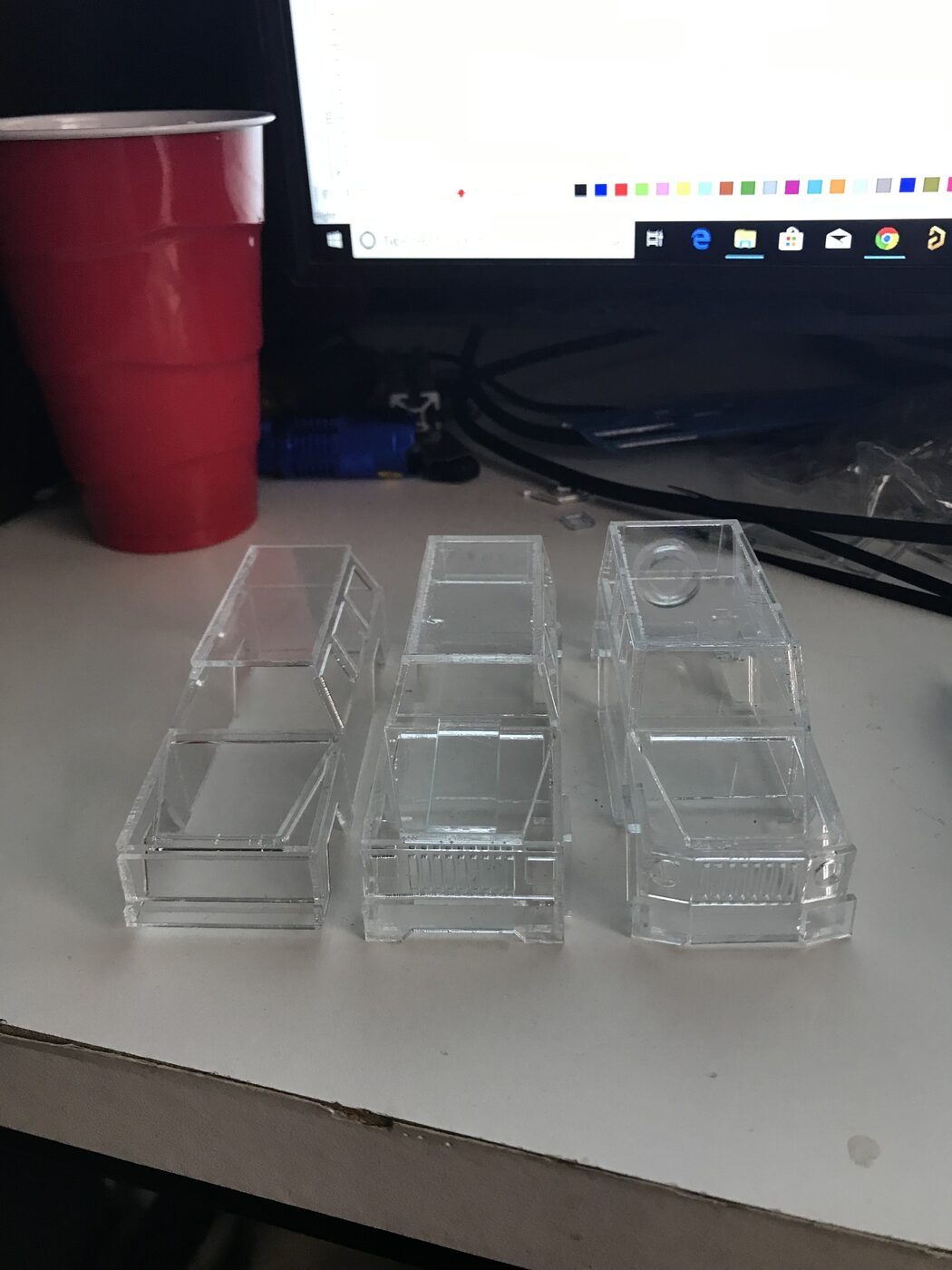 Three laser-cut clear acrylic SUV bodies side by side, each a different iteration