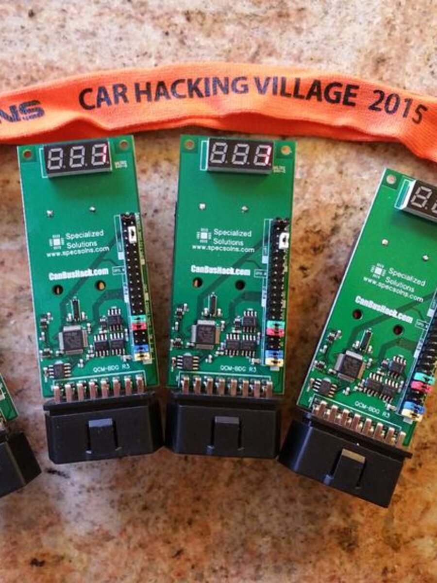 Two green Car Hacking Village badge boards with OBD-II connectors and three-digit displays